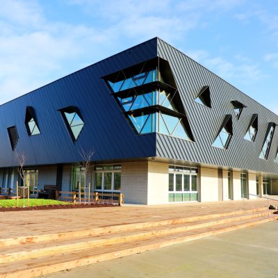 Exterior of a building with triangular windows and wooden steps