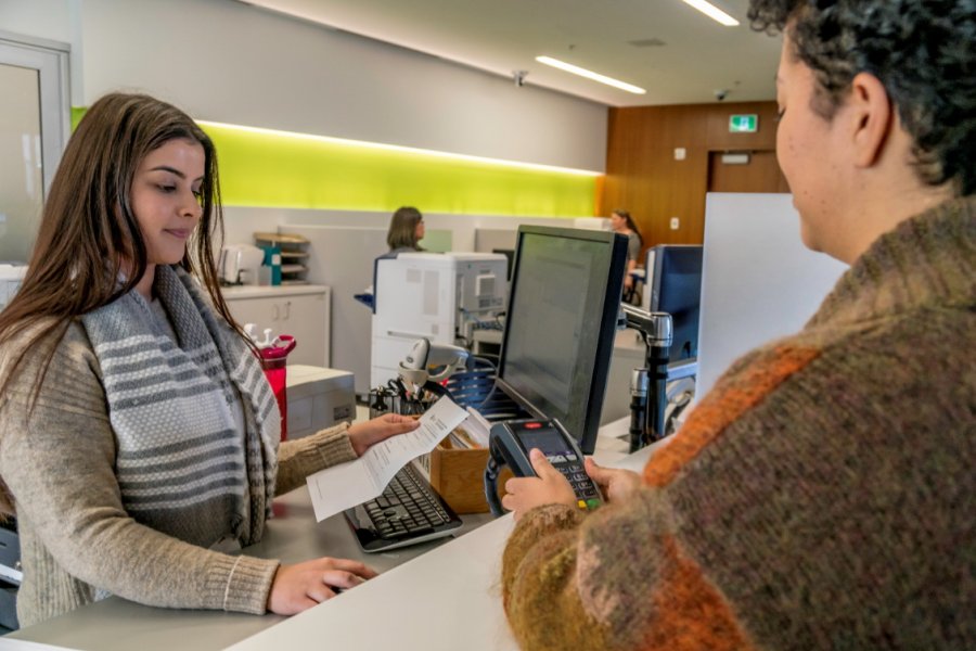 Woman using debit machine at City Hall