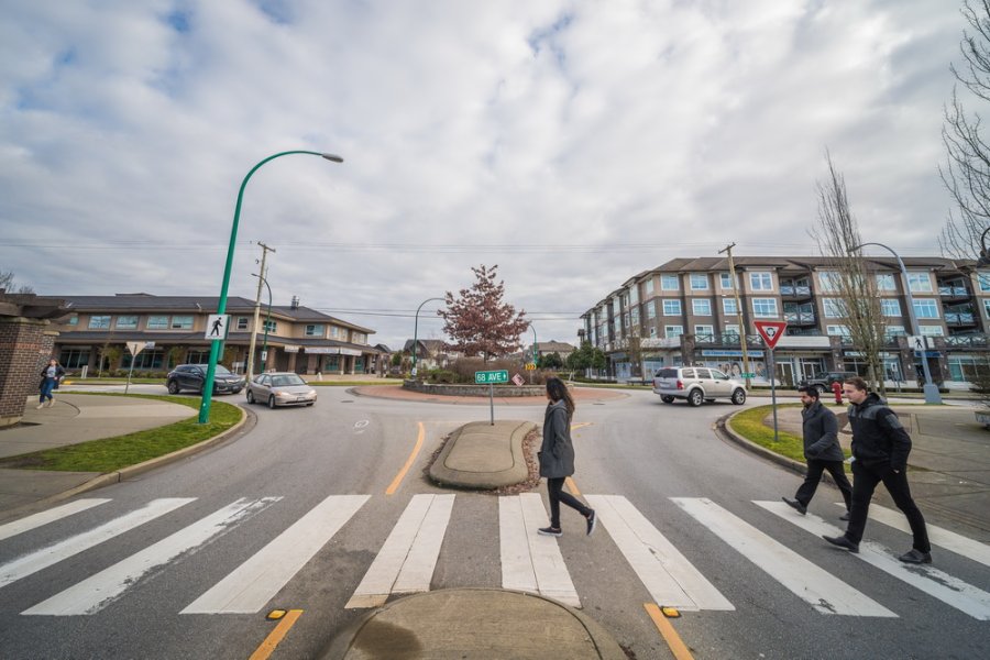 3 people using a crosswalk at a roundabout