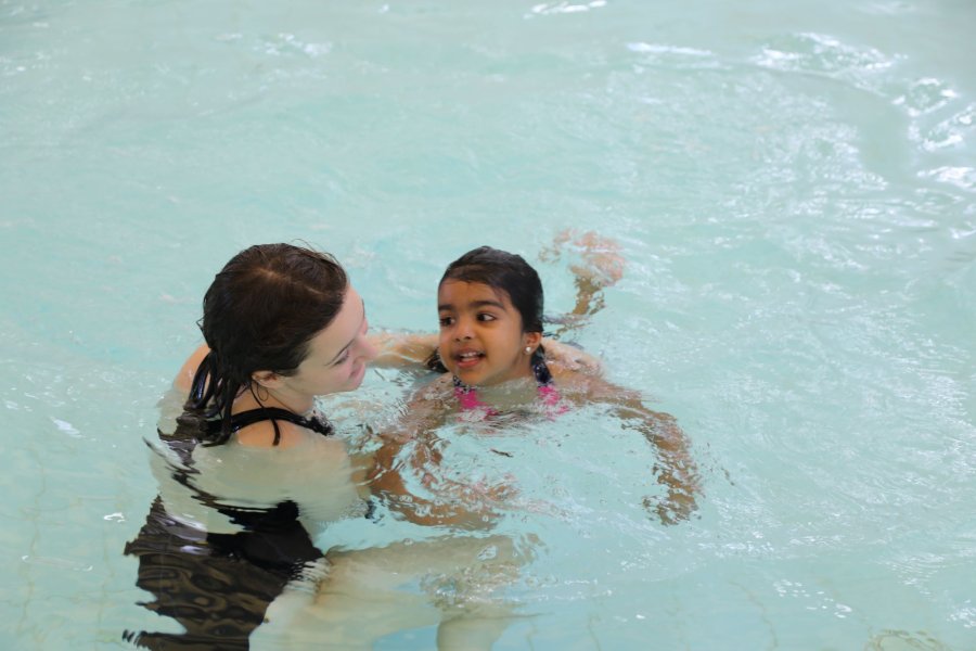 A parent swimming with their child.